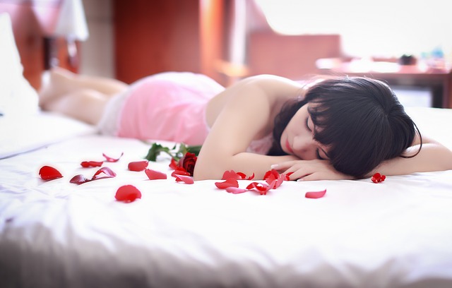 dívka na posteli s lístky růží